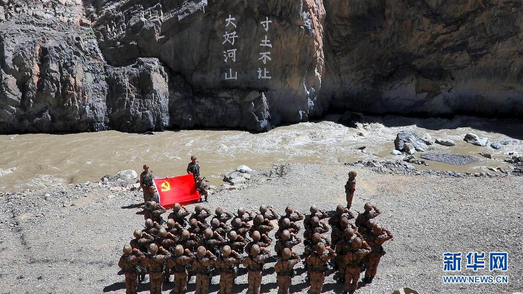 某边防团官兵在“大好河山 寸土不让”标语前举行重温入党誓词仪式（资料照片）。新华社发（郑晓林 摄）